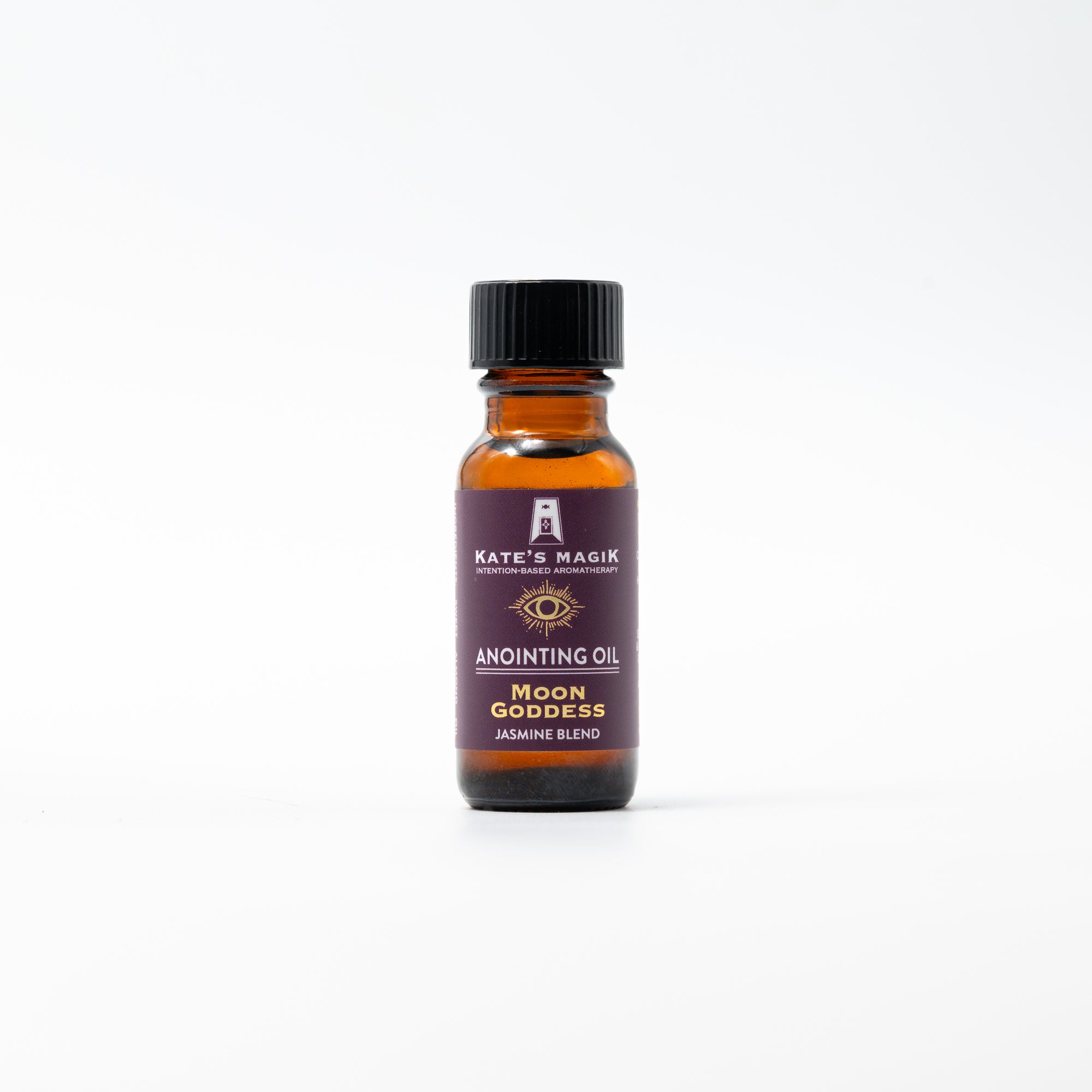 A small amber glass bottle of Kate's Magik Anointing Oil, Moon Goddess Jasmine Blend, with a black cap and a dark purple label, centered on a clean white background.