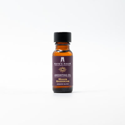 A small amber glass bottle of Kate's Magik Anointing Oil, Moon Goddess Jasmine Blend, with a black cap and a dark purple label, centered on a clean white background.
