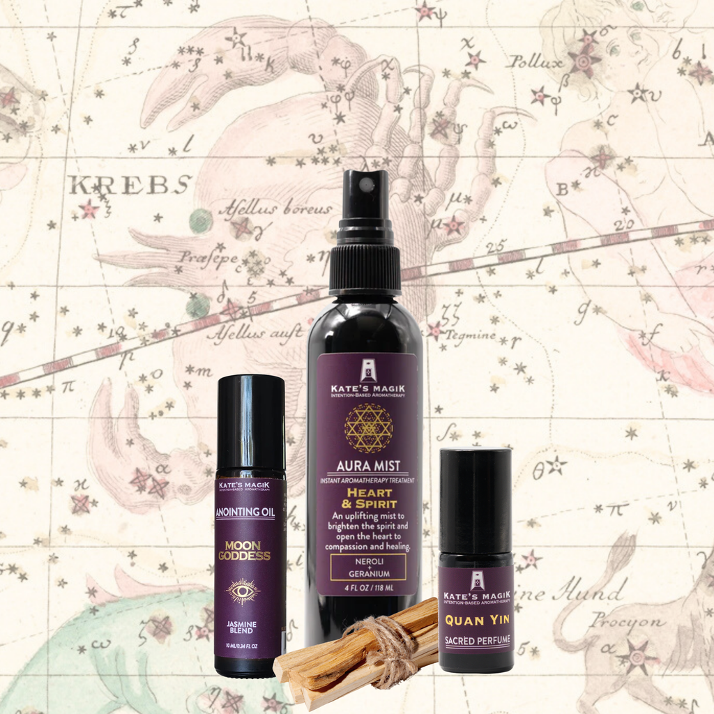 A product bundle made for the Cancer Zodiac from Kate's Magic featuring a large 'Aura Mist' spray bottle called Heart & Spirit, a 'Moon Goddess' roll-on anointing oil bottle, and a Quan Yin Sacred perfume roll-on bottle. The set is arranged with a bundle of Palo Santo sticks in front of a celestial Cancer zodiac chart background, featuring a medieval drawing of a crab amongst the stars. 