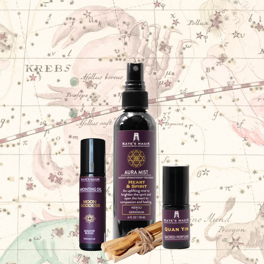 A product bundle made for the Cancer Zodiac from Kate's Magic featuring a large 'Aura Mist' spray bottle called Heart & Spirit, a 'Moon Goddess' roll-on anointing oil bottle, and a Quan Yin Sacred perfume roll-on bottle. The set is arranged with a bundle of Palo Santo sticks in front of a celestial Cancer zodiac chart background, featuring a medieval drawing of a crab amongst the stars. 